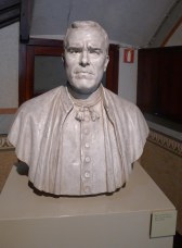 Bust de Mn. Cinto Verrdaguer al peu de l'escala.