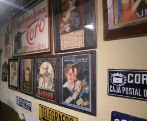 Cartells a la paret de l'estanc on es pot veure l'anunci d'un nen amb un cigarret a la boca.