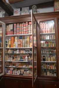 La farmàcia. Armari amb les prestatgeries plenes.