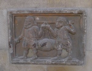 Relleu de bastaixos portant una bòta a la manuella.