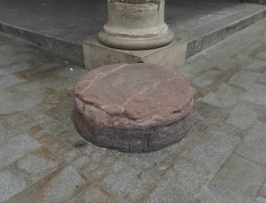 Pedra a l'encant al peu d'una columna de la Porxada.