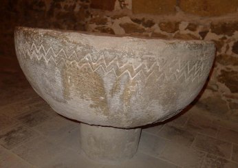 Pica baptismal als peus de l'església.