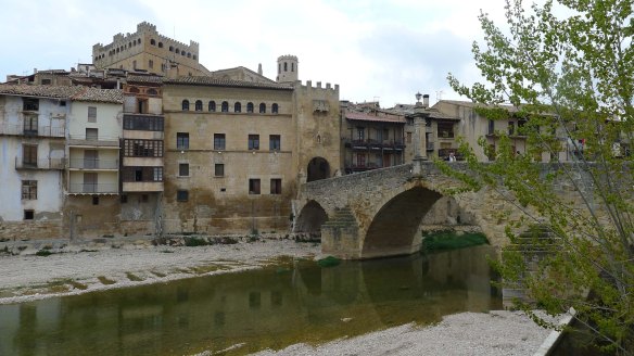 Pont de pedra amb la porta de Sant Roc i, sobressortint, el castell i el campanar.
