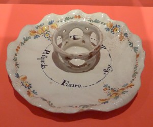 Plat per encaixar-hi una xicra amb el nom de la propietària. S. XVIII.